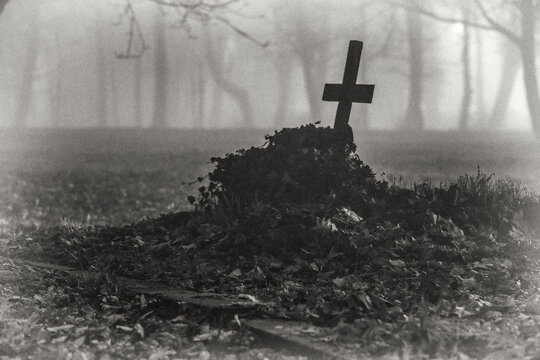 stary zapomniany cmentarz w nocy z sylwetkami krzyży i grob&oacute;w