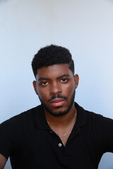 Obraz premium Vertical headshot of African American man over isolated white background looking at the camera. Isolated.