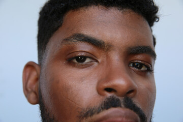 Close-up headshot of African American man over isolated white background looking at the camera. Isolated.