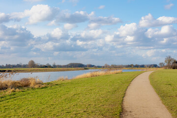 Landscape view of the river under blue sky, The IJssel is a Dutch distributary of the river Rhine that flows northward and ultimately discharges into the IJsselmeer, Deventer, Overijssel, Netherlands.