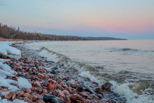 winter sunset on the shore of lake superior, grand marais, minnesota