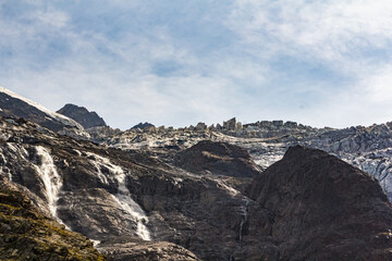 Melting glacier creates waterfalls flowing down mountainside