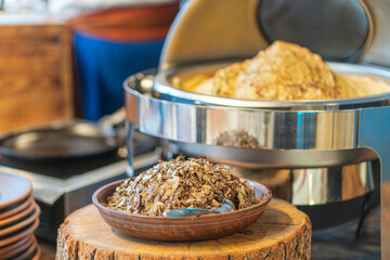 Image depicts a rustic kitchen scene with dark grainsseeds, metal lids, and a cooking pan Warm tone suggests preparation in a kitchen environment