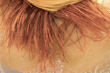 Image depicts a fluffy-rimmed, neutral-colored hat with potential white or light beige base The...