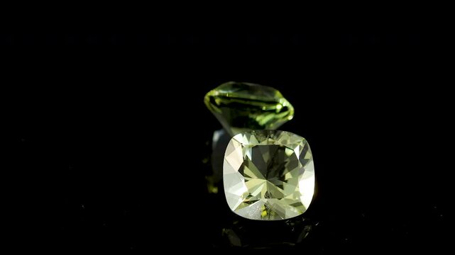 Heliodor, Golden beryl faceted scissors cut stone mineral macro video is spinning in a circle on black