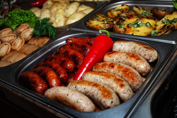 Varied assortment of hot ready-made dishes cooked on the grill. Selling food products at a street fair. Fast food. Street food to go.