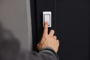 Man ringing doorbell of his friends apartment, closeup