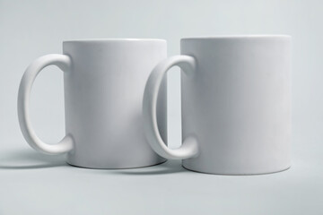Two blank mugs for branding on light grey background. Mockup for design