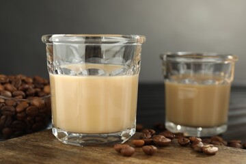 Coffee cream liqueur in glasses and beans on table, closeup