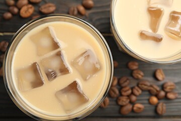 Coffee cream liqueur in glasses and beans on wooden table, flat lay