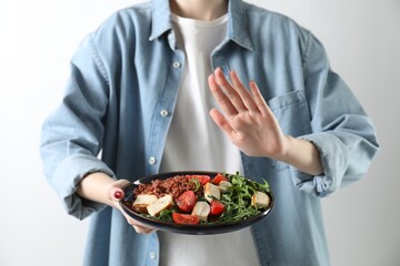 Woman refusing to eat meal on white background, closeup. Food allergy concept