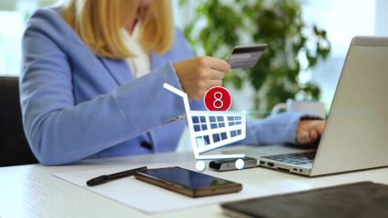 Businesswoman using a credit card for online payment with a 3D graphic overlay of a shopping cart, symbolizing e-commerce