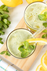 Fresh lemon mint smoothie on white kitchen table. Top view. Healthy homemade green lemonade.