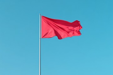 A vibrant red flag flutters prominently against the clear blue sky.