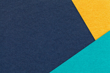 Fototapeta premium Texture of craft navy blue color paper background with yellow and turquoise border. Vintage abstract denim cardboard