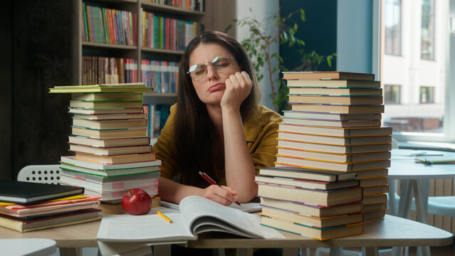 Caucasian tired woman girl high school student exhausted overwork teacher pupil student sad upset studying exam stress difficult learn problem education literature boring read books library university