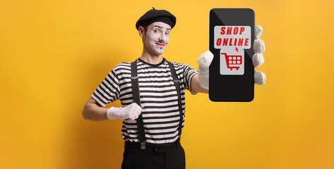 Mime holding a smartphone with text online shopping on the screen