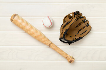 Baseball glove and bat with ball on wooden background, top view