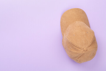 Beige velvet cap on color background, top view