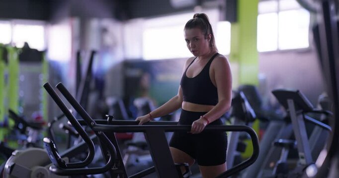 Cute overweight woman exercising on a treadmill at the gym, focusing on weight loss, endurance training, and cardio fitness while tracking her progress and staying committed to her fitness journey