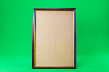 Fototapeta premium Wooden frame on a green background