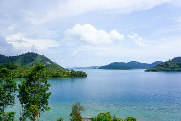 Serene Tropical Island Surrounded by Crystal Clear Blue Water and Lush Green Hills
