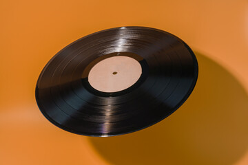 Floating vinyl record with shadow on yellow background
