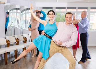 Adult man and young woman dancing in dance class