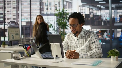 Professional businessman joins a digital meeting to discuss enterprise solutions and project goals. Attending a telecommuting session with shareholders for organizational development. Camera B.