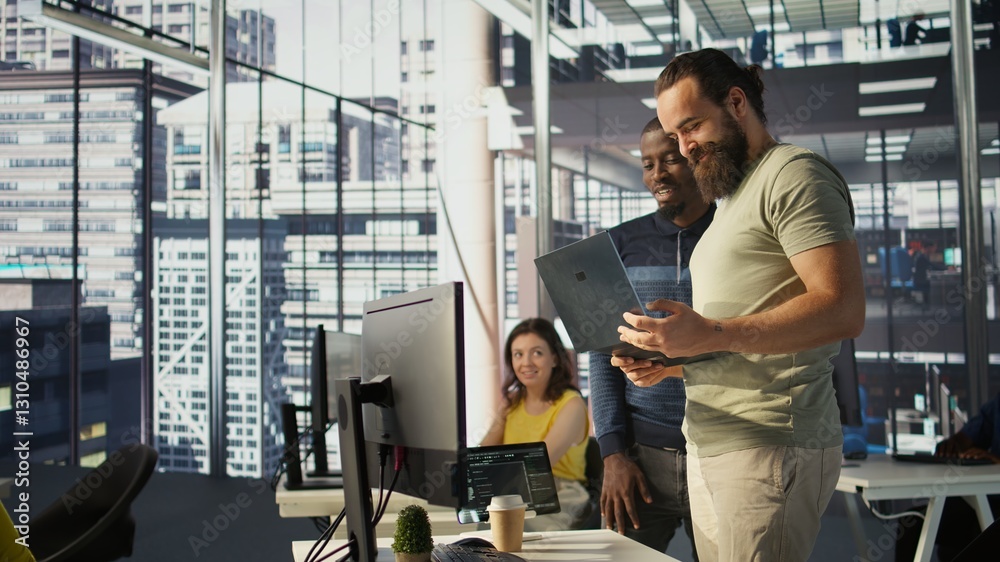 Poster cheerful admin holding laptop chatting with colleagues while working with machine learning tech. man