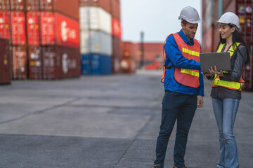Obraz premium Two logistics workers man and woman discuss operations at a busy shipping container yard.