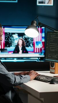 Vertical Video African american expert at desk using pc for programming and data analysis. Young networking expert working from his home setup, manages information technology and data center. Camera B