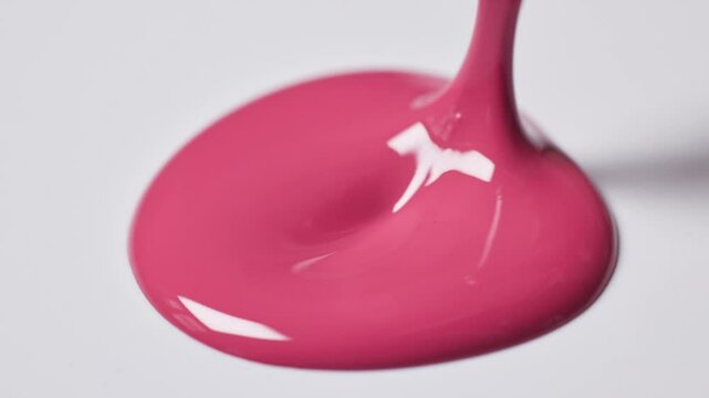 pink nail polish drop on white  background and a brush showing perfect smooth texture, closeup macro