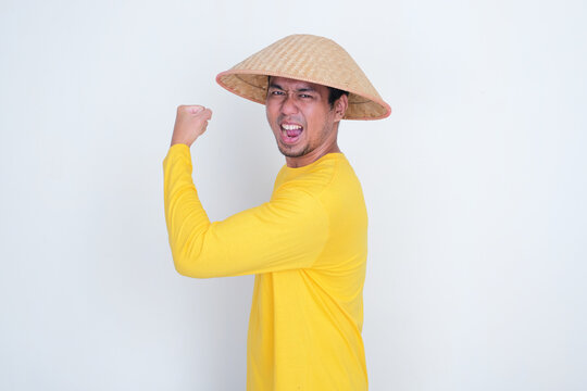 Side view of Indonesia farmer showing his arm biscep muscle with excited expression
