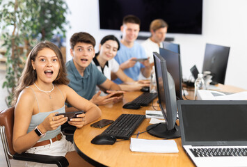 Student are engrossed in their mobile phones, working diligently on their tasks.