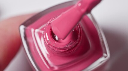 pink nail polish bottle on white  background and a brush showing perfect smooth texture, cosmetic product closeup macro, top view