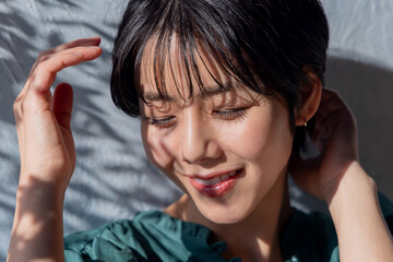 Fototapeta premium 壁に寄りかかるワンピースの女性 