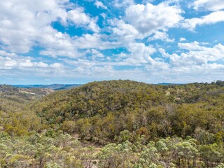 Naklejka premium Aerial View of a mountain landscape with blue sky out at the Ottery Arsenic Mine near Tent Hill, NSW, Australia