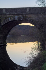 Roman bridge of Caparra Extremadura with a single eye and a vertical reflection in the water