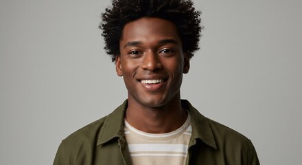 Obraz premium Waist-up studio portrait of a young male model looking into the camera with a cheerful expression. He is wearing a T-shirt and an overshirt.