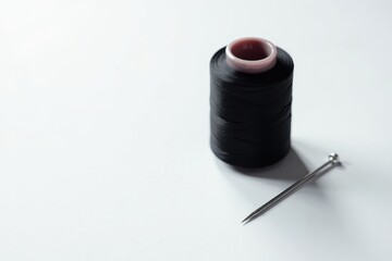 Black sewing thread spool and needle on white , accessories, fabric