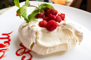 Sweet meringue dessert with berries on a plate in a restaurant.