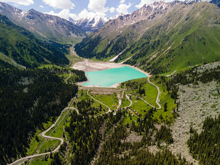 View of Big Almaty Lake from above. High-mountain lake not far from Almaty, popular place for tourists to visit. Picturesque view in the mountains from a drone.