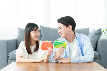 財布と通帳を持つ夫婦