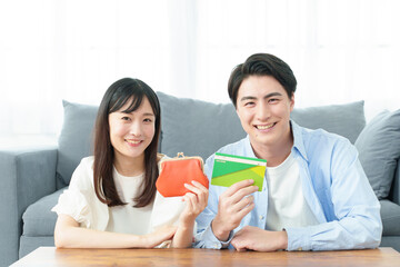 Obraz premium 財布と通帳を持つ夫婦