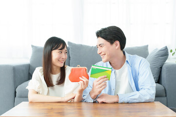 財布と通帳を持つ夫婦