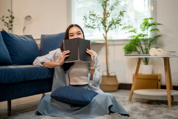 A woman is sitting on the floor with a book in her hand