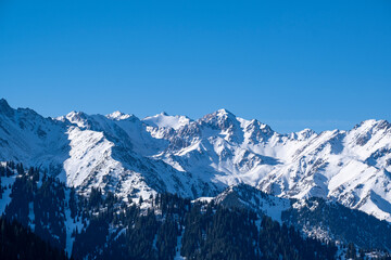 Obraz premium Snowy mountain peaks not far from Almaty, mountain views from kumbel peak. A popular tourist route in the mountains.