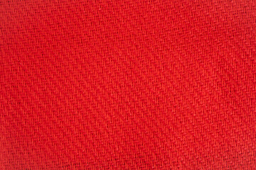 Texture of woolen blanket, bright woolen threads woven into fabric. Beautiful bright red woolen blanket.