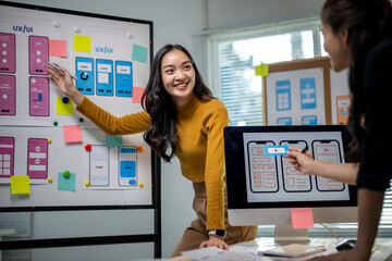 A woman is standing in front of a white board with a smile on her face